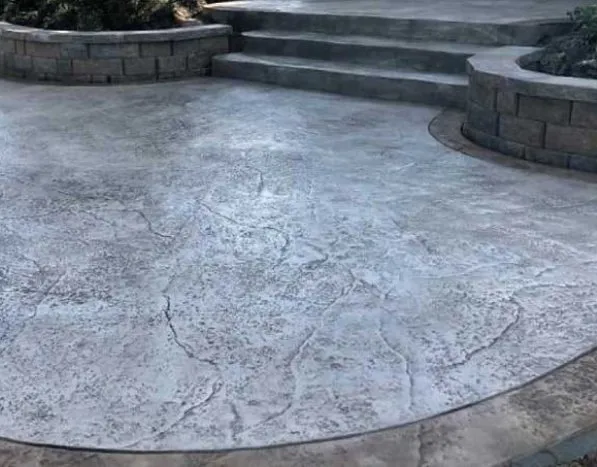 Patio con escalones y suelo de hormigón impreso gris de piedra irregular