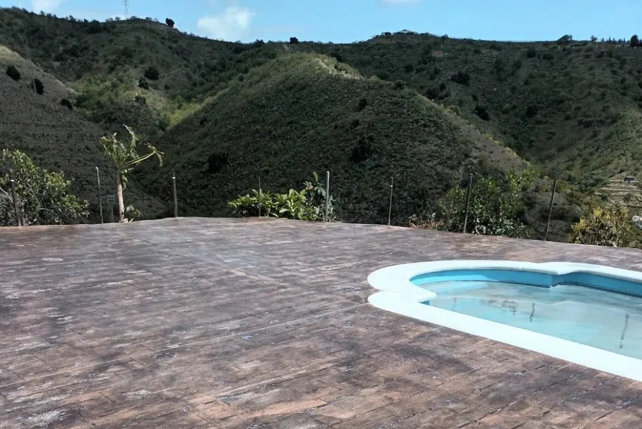 Suelo de hormigón impreso imitación madera alrededor de una piscina con vistas a la montaña