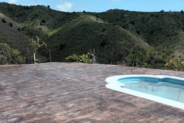 Piscina rodeada de suelo de hormigón impreso imitación madera con vistas a la montaña