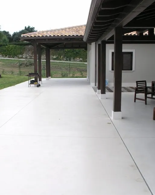 Porche de vivienda con suelo de hormigón continuo en tono claro