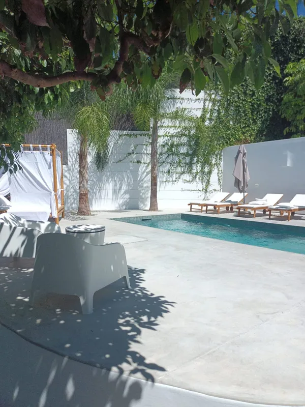 Zona de piscina con pavimento de hormigón en tono claro