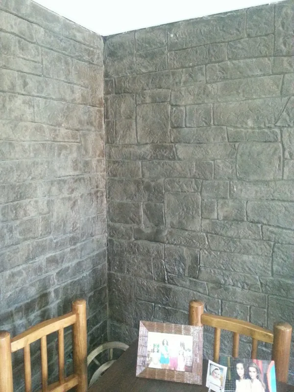 Pared de patio con hormigón impreso vertical imitación sillería