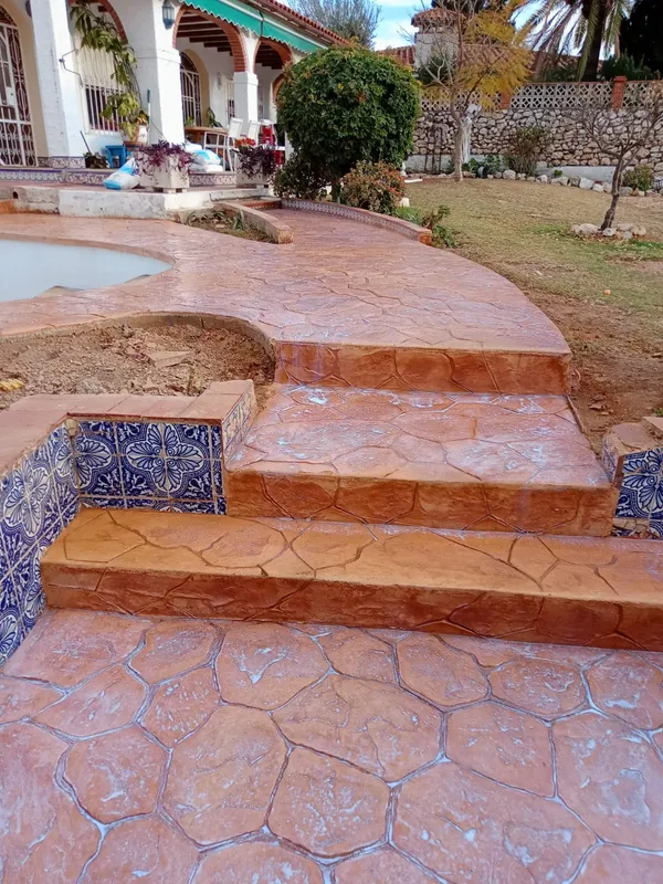 Escalones y zona de piscina con hormigón impreso terracota