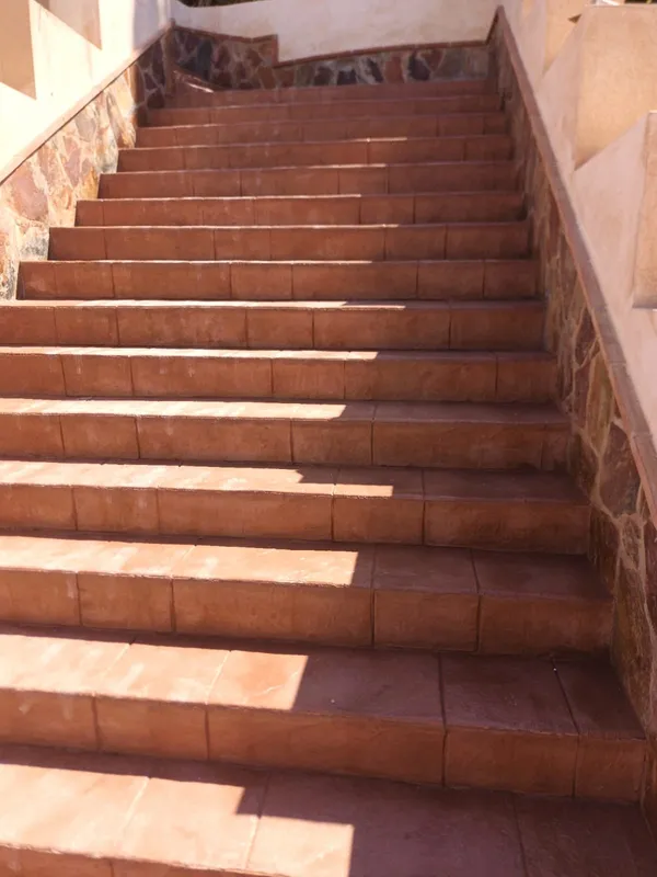 Escalera exterior revestida con hormigón impreso terracota