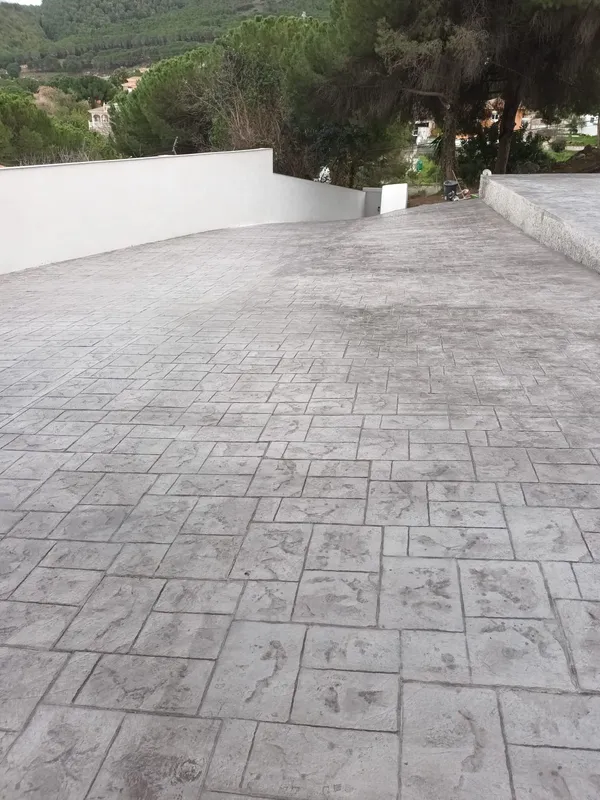 Rampa de acceso amplia con hormigón impreso gris